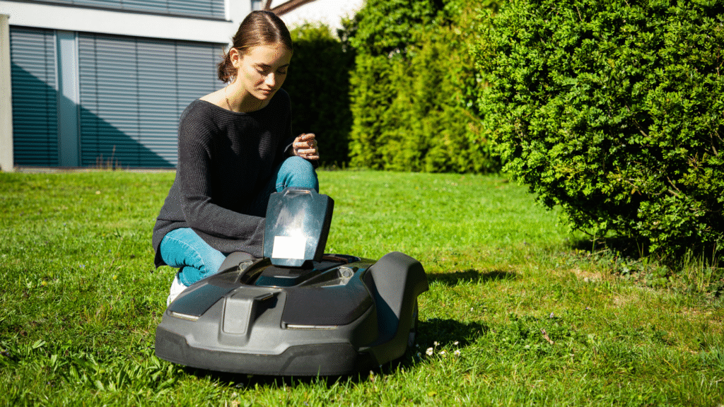 Best robot lawn mower: image depicts woman starting up robot mower on lawn
