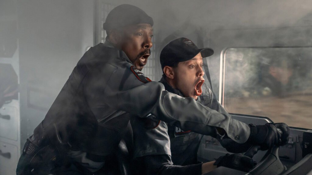 Eddie Murphy and Pete Davidson scream while holding the steering wheel of a car