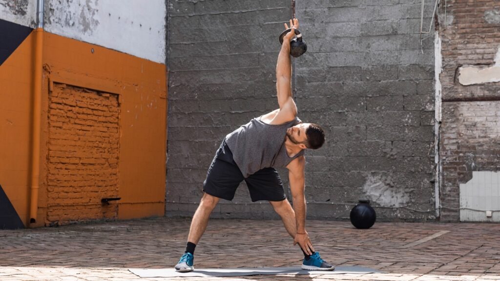 a photo of man doing a kettlebell windmill
