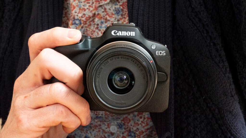 Canon EOS R100 camera in the hand