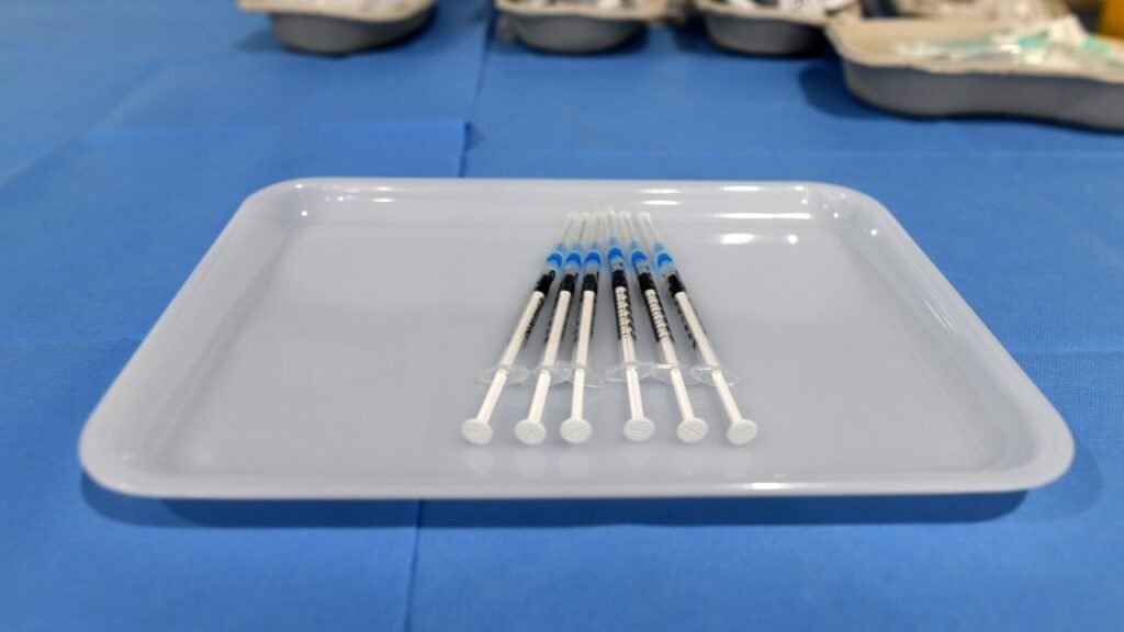 Hypodermic needles lined up in a tray.