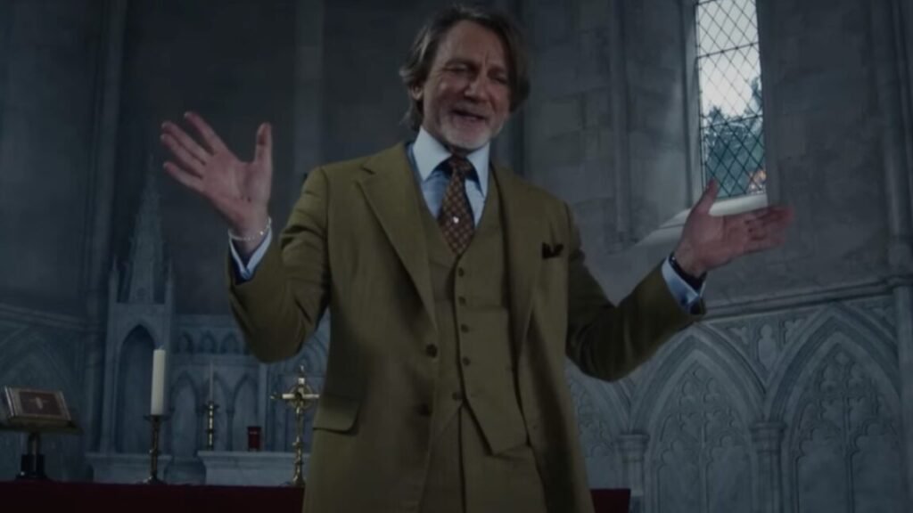 older southern gentleman with shoulder length gray-blonde hair standing in a church with both hands held up expressively