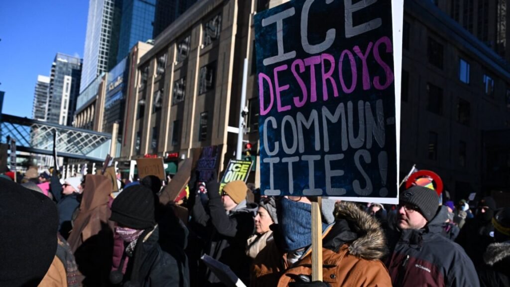 ICE protester says her Global Entry was revoked after agent scanned her face People wearing winter coats, hats, and gloves take part in a march against US Immigration and Customs Enforcement (ICE) in Minneapolis, Minnesota. One person holds a sign that says, "ICE destroys communities!"