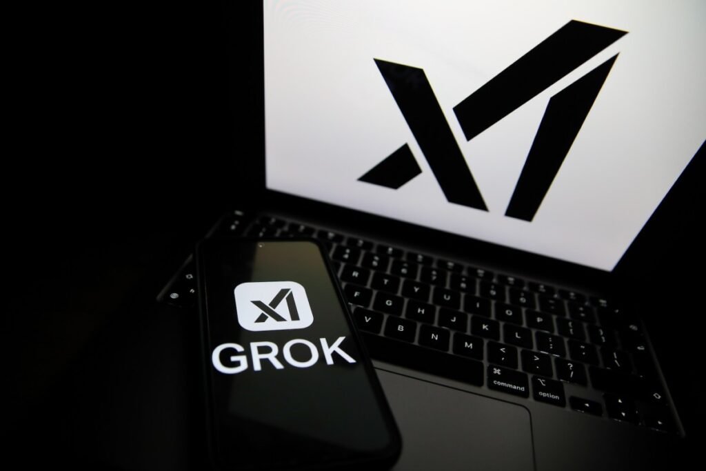 India orders Musk’s X to fix Grok over “obscene” AI content The Grok logo appears on a phone and the xAI logo is displayed on a laptop.