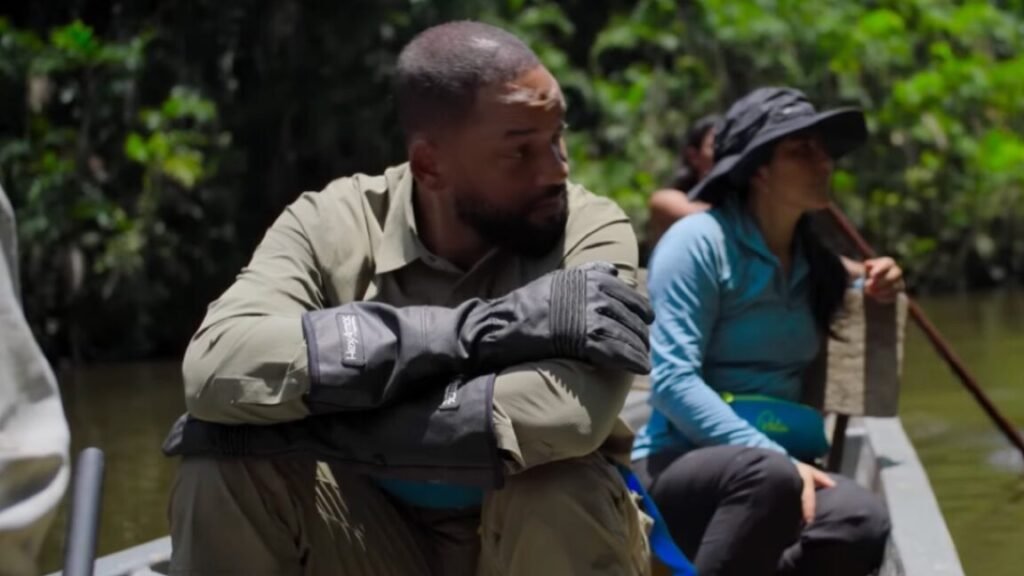 That time Will Smith helped discover new species of anaconda actor will smith in khakis seated with arms folded on is knees in a canoe rowing down a tropical river
