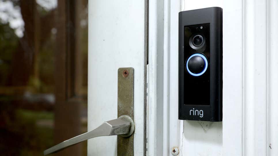 An image of a Ring doorbell camera placed next to a door.