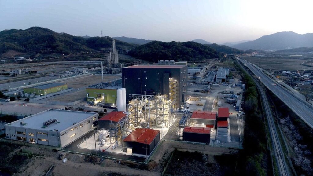 A battery materials factory is lit up at dusk.