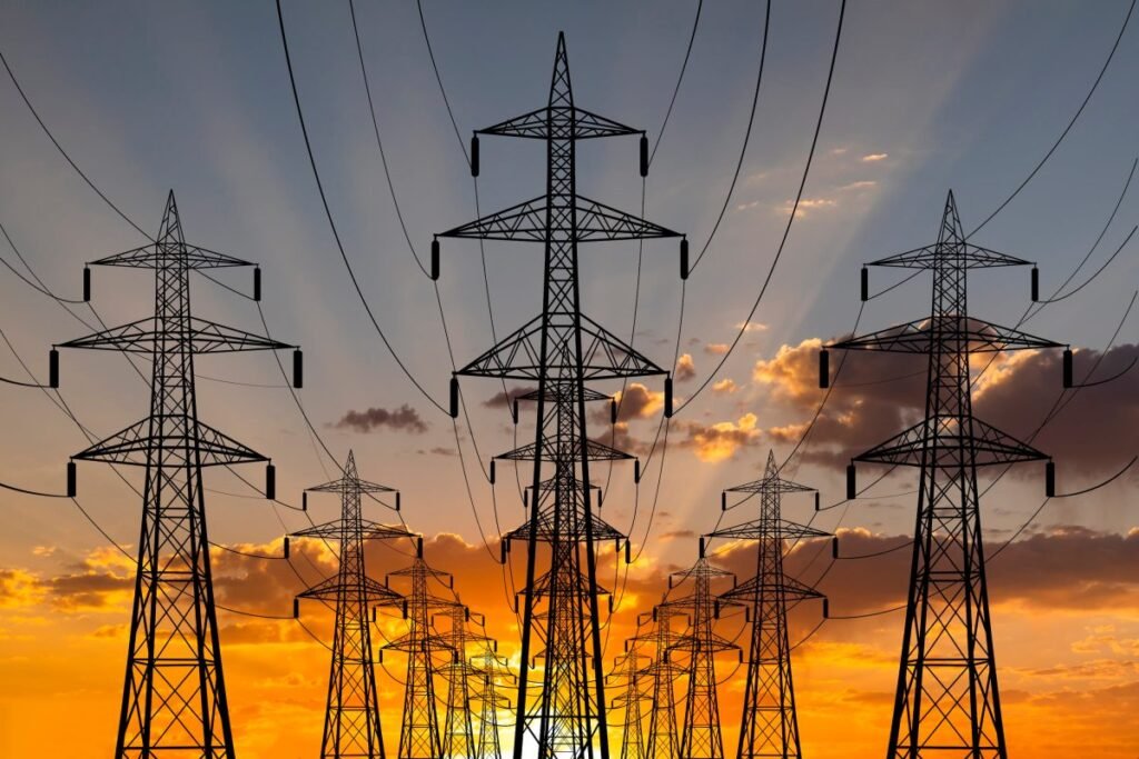 The sun sets behind transmission lines.