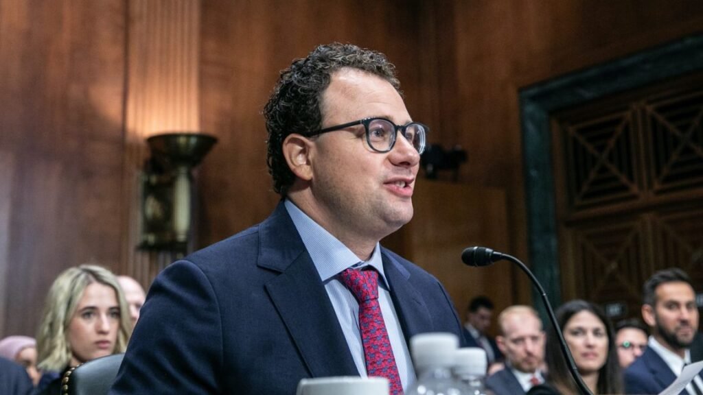 Anthropic CEO Dario Amodei sitting at a table and speaking into a microphone during a Senate committee hearing.