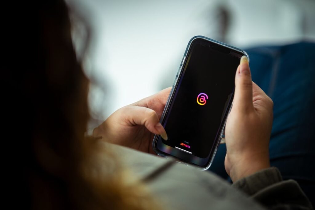 Woman holding a smartphone and looking at a social media app on the screen