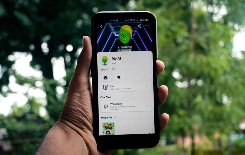Man holding a smartphone showing the Snapchat app on screen