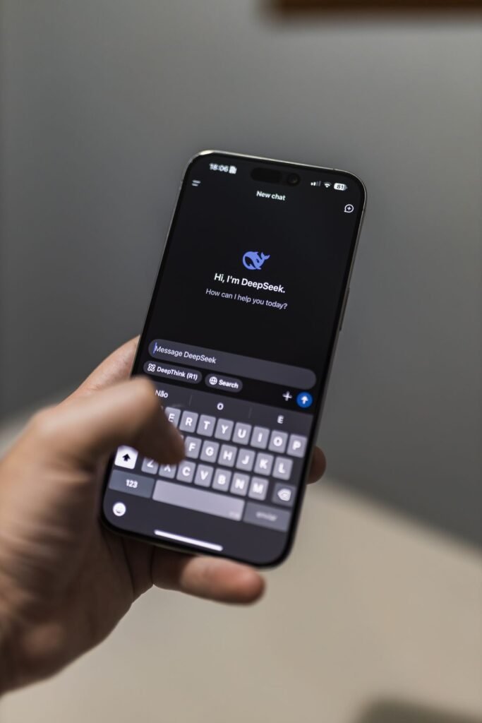 Hand holding a smartphone showing an AI chat application