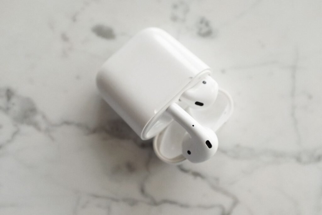 Best AirPods in 2026: Which Pair Should You Buy? Apple wireless earbuds resting in an open charging case on a marble surface