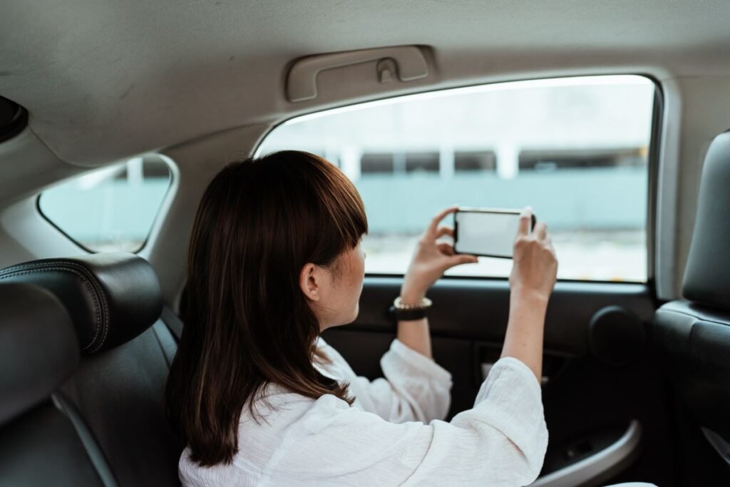 Passenger using a smartphone from the seat of a ride sharing car