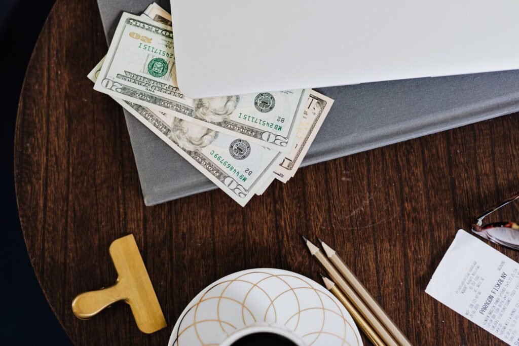 Laptop on a desk with US dollar bills underneath it, illustrating how to monetize a WordPress blog