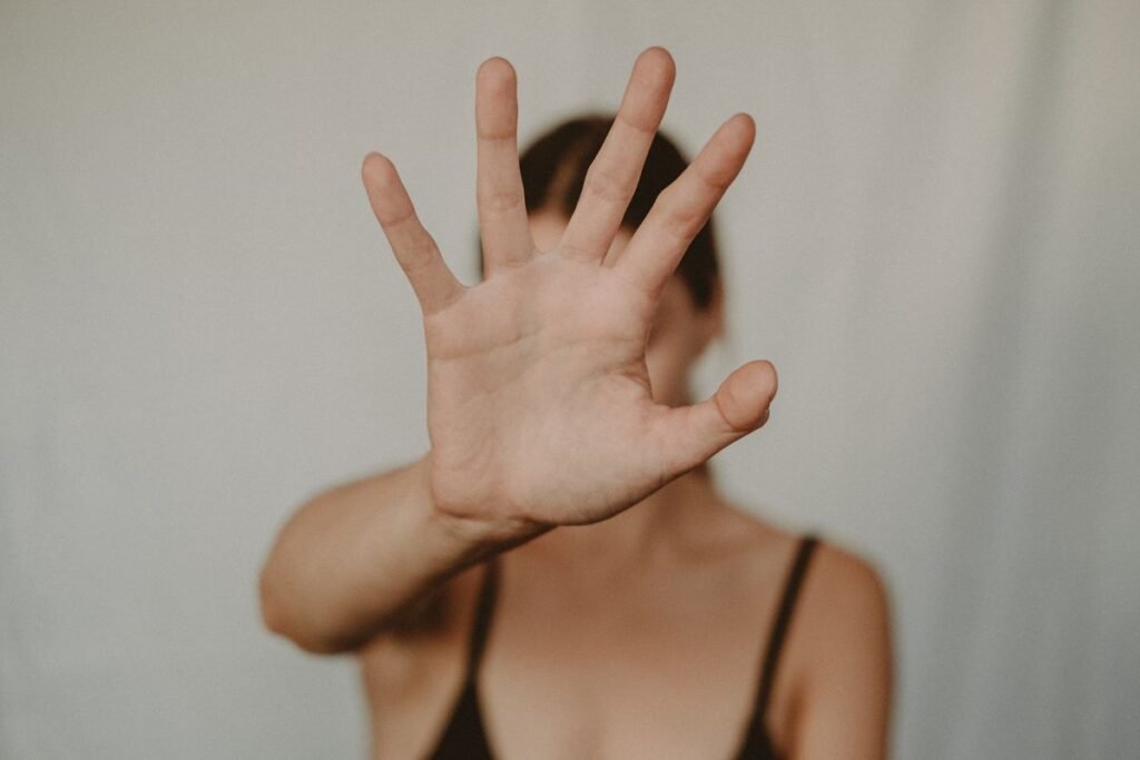 Woman showing a stop gesture with her hand to block someone