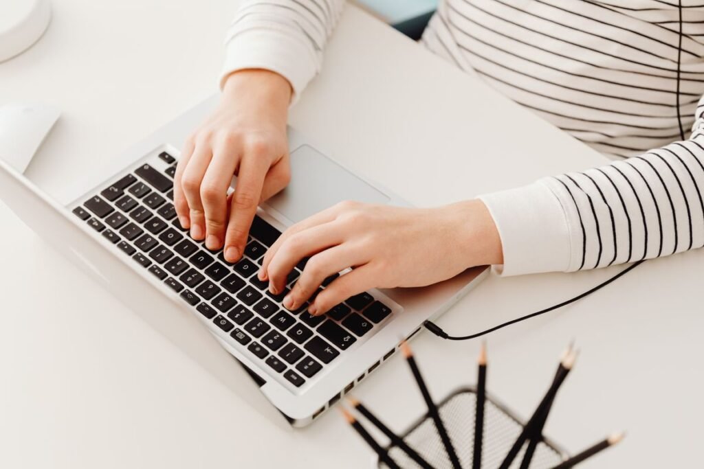 Person sitting at a desk typing on a laptop
