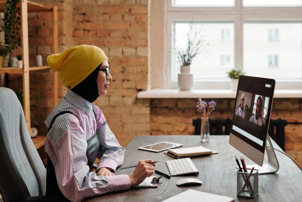 How to Enable a Virtual Background in Zoom Woman sitting in an office talking on a webcam video call on her computer