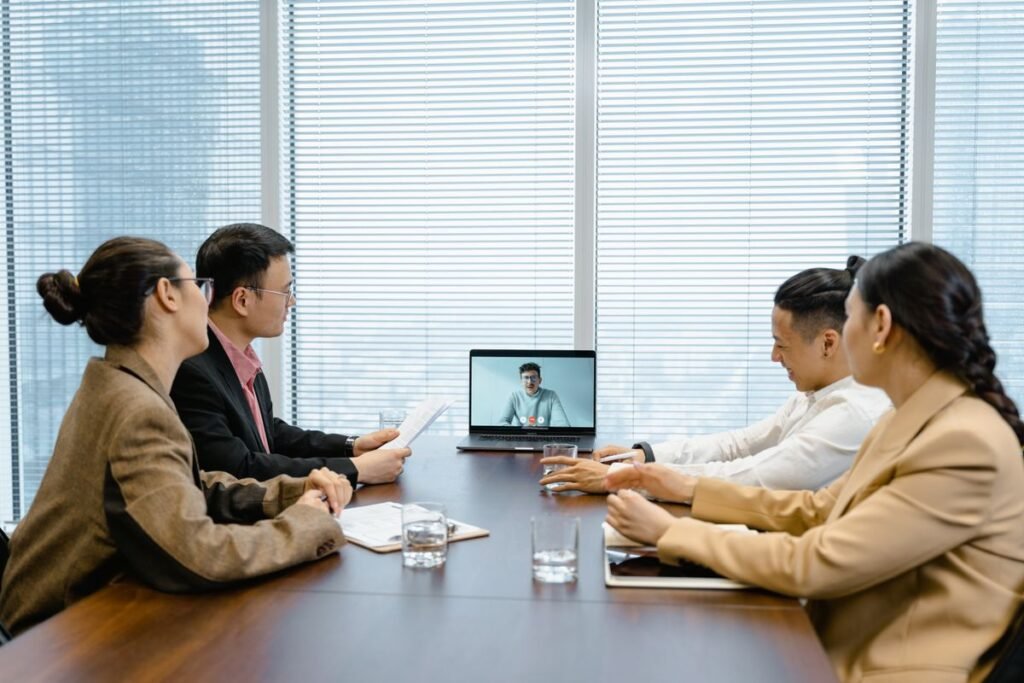 A group of people in a meeting using a video call on screen