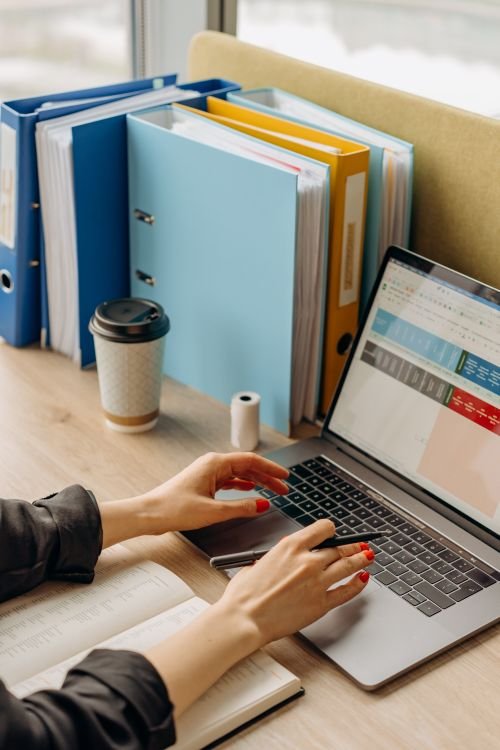 How to Free Up Space on Windows 11: 5 Easy Ways A person using a laptop at a desk to manage files and settings