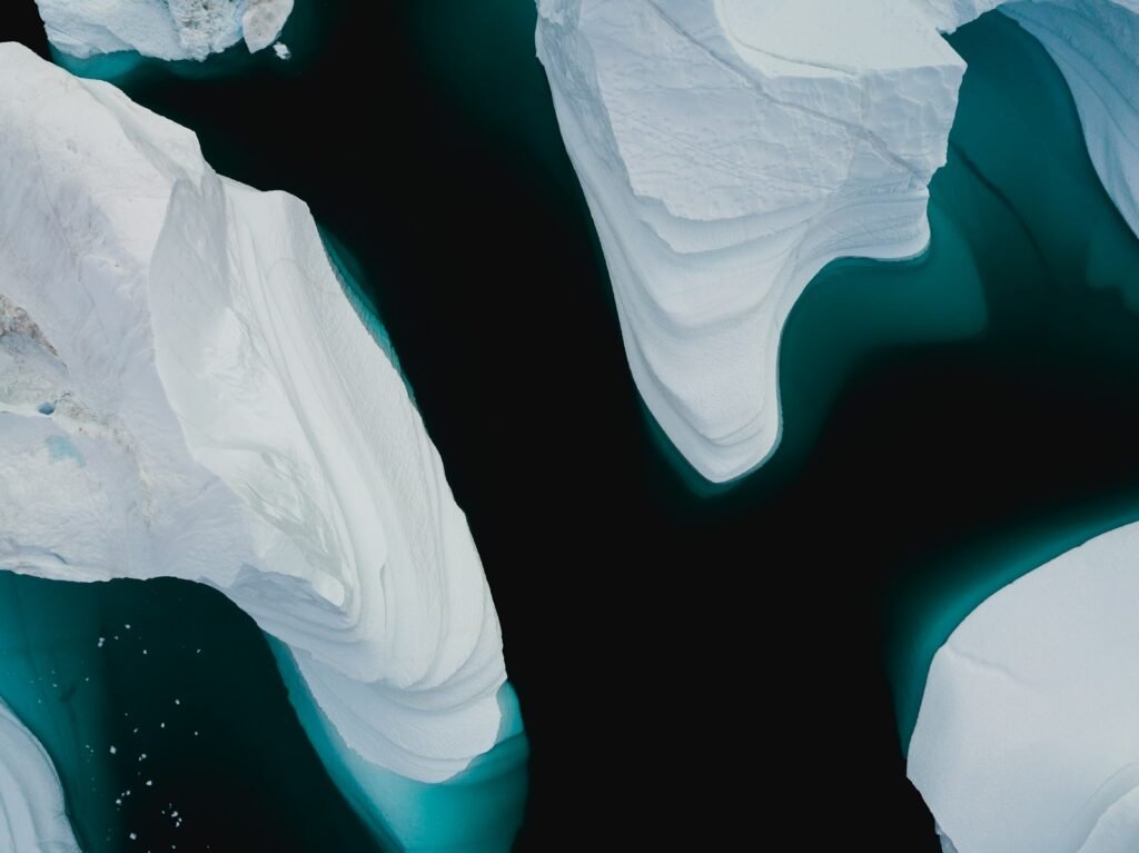 Aerial view of Arctic icebergs and fragmenting sea ice in dark ocean water