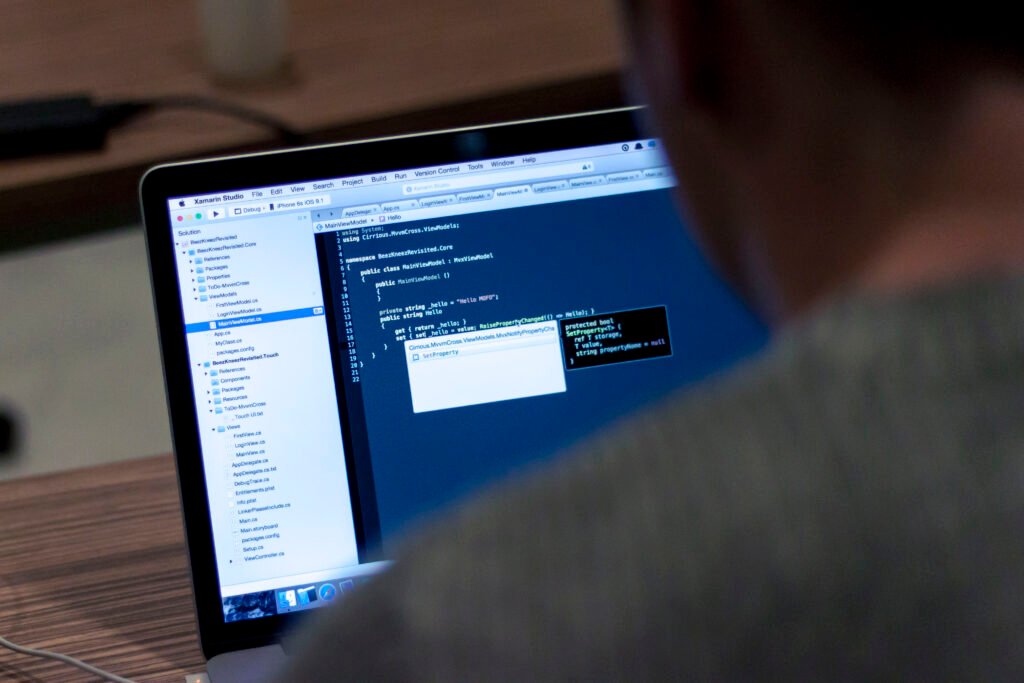 Grok 4.6 Arrives With a Big Coding Push, and a Familiar Blind Spot Developer coding on a laptop, representing SpaceXAI's Grok 4.6 agentic coding model