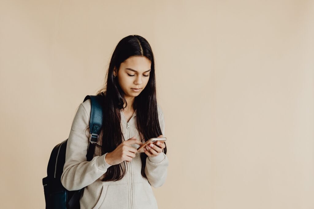 OpenAI Gave Teenagers Their Own ChatGPT. On Day One It Wrote the Essay Anyway. A teenage student using a smartphone, illustrating ChatGPT for Teens
