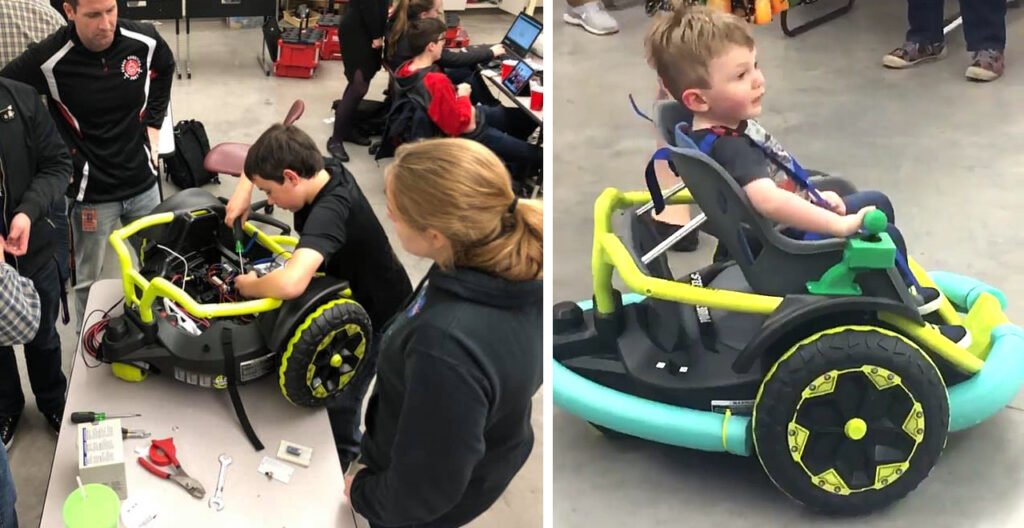 Two-year-old Cillian Jackson smiling as he drives the yellow and teal power wheelchair built for him by Farmington High School's robotics team