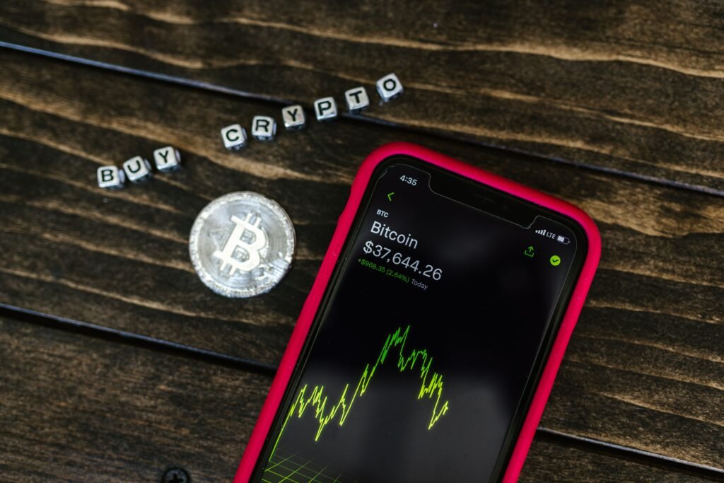 A smartphone displaying cryptocurrency next to a physical coin