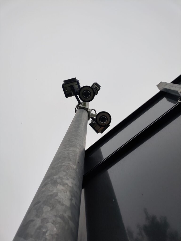 A Florida Officer Ran His Wife’s Plate 717 Times. The System Asked Why and Believed Him. Security cameras mounted high on a street pole, illustrating automated license plate reader surveillance networks