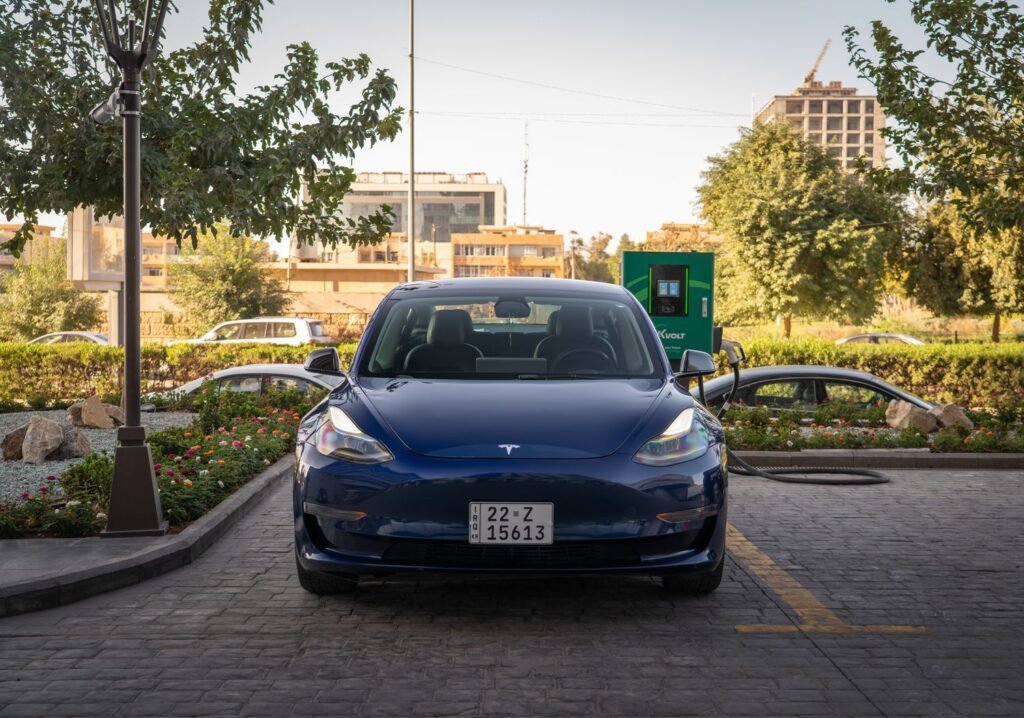 One Clause on Page 5 Could Hand Elon Musk $824 Billion Without a Single Robotaxi Blue Tesla Model 3 plugged in and charging at an outdoor charging station