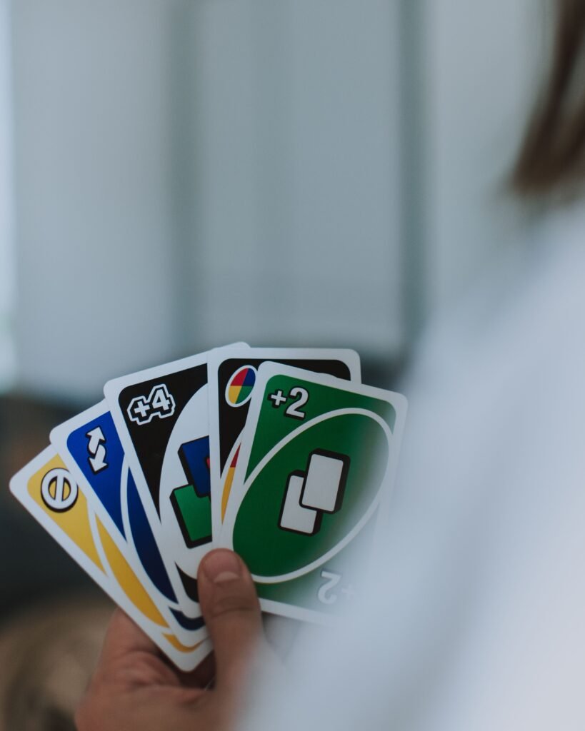 A person holding a hand of colorful UNO cards, illustrating Mattel's UNO Championship Series and its $50,000 grand prize