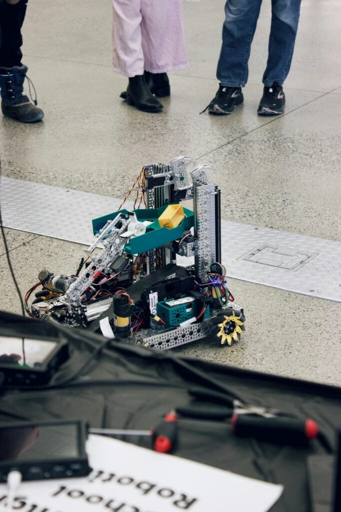 High school students assembling a robot at a workbench in a school engineering lab