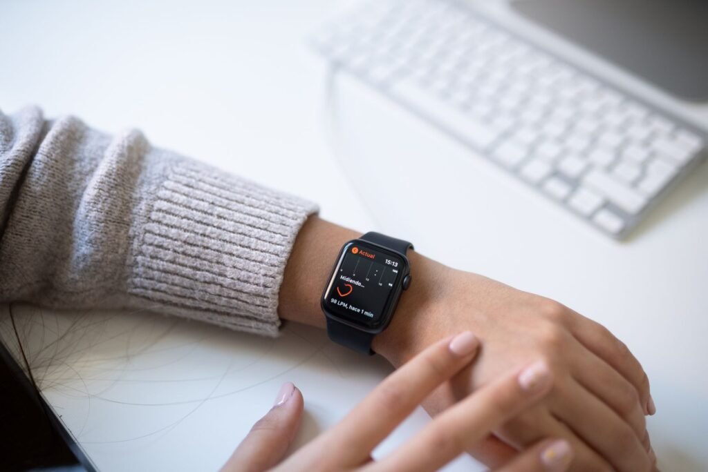 Person wearing a black smartwatch and checking health stats on the wrist