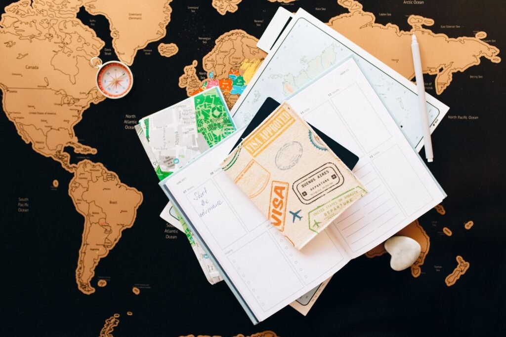 Passport, travel documents and a planner laid out on a world map, illustrating the Find Hub Remembered feature in the September Android Drop