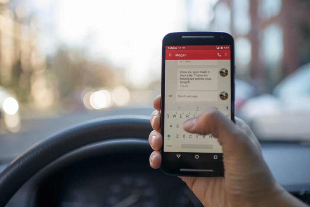 Person sitting inside a car holding an Android smartphone, illustrating the Motion Assist car sickness feature