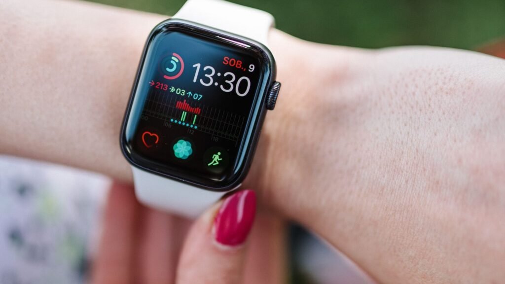 Close-up of a person wearing an Apple Watch displaying fitness data on the wrist outdoors