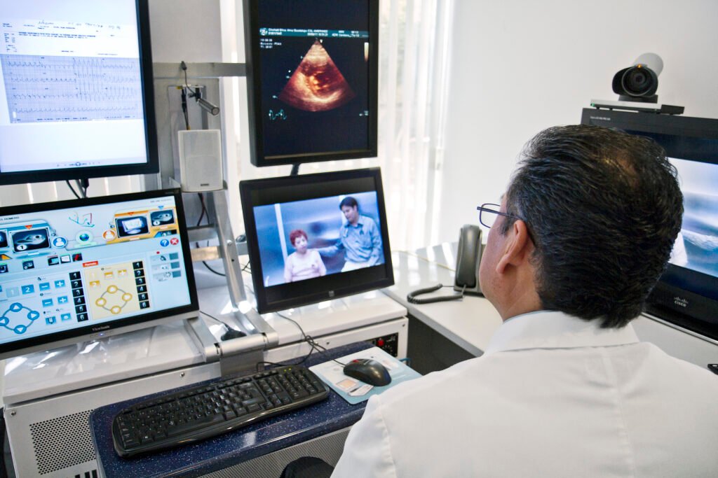Doctor reviewing a patient's electronic health record on a computer screen during a telemedicine consultation