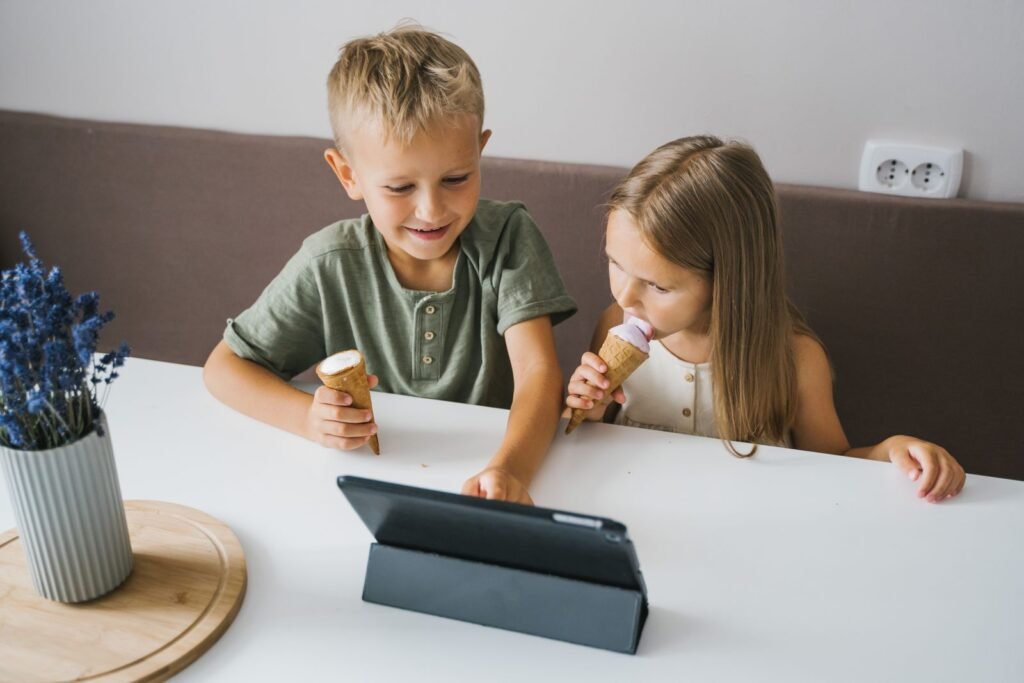 Health Officials Finally Put a Number on Screen Time. Teenagers Are Running Four Times Over It. Two young children sitting together and staring at the screen of a tablet