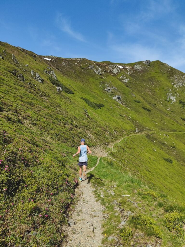 Coros Pace 4 Pro Packs 60 Hours of GPS Into a Titanium Case, for $300 Less Than Garmin’s Watch Runner on a mountain trail wearing a GPS sport watch similar to the Coros Pace 4 Pro