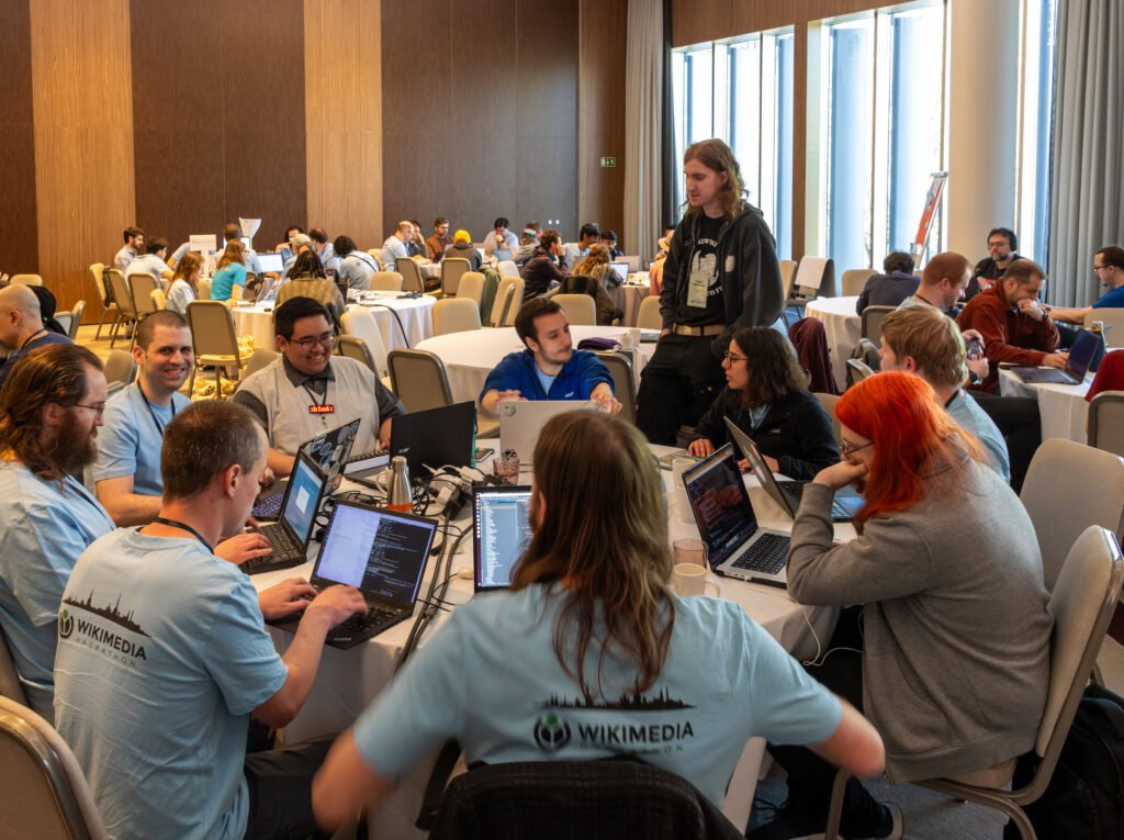 A group of developers collaborating together on laptops at a hackathon table