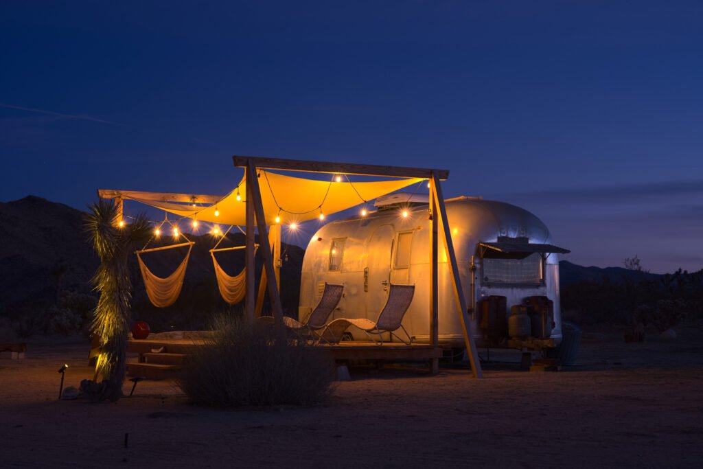 A polished aluminum 1963 Airstream travel trailer parked outdoors in the desert at Joshua Tree