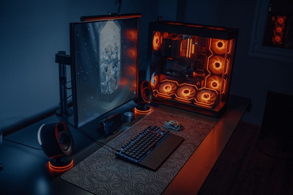 PC gaming desk setup with RGB lighting and a large monitor