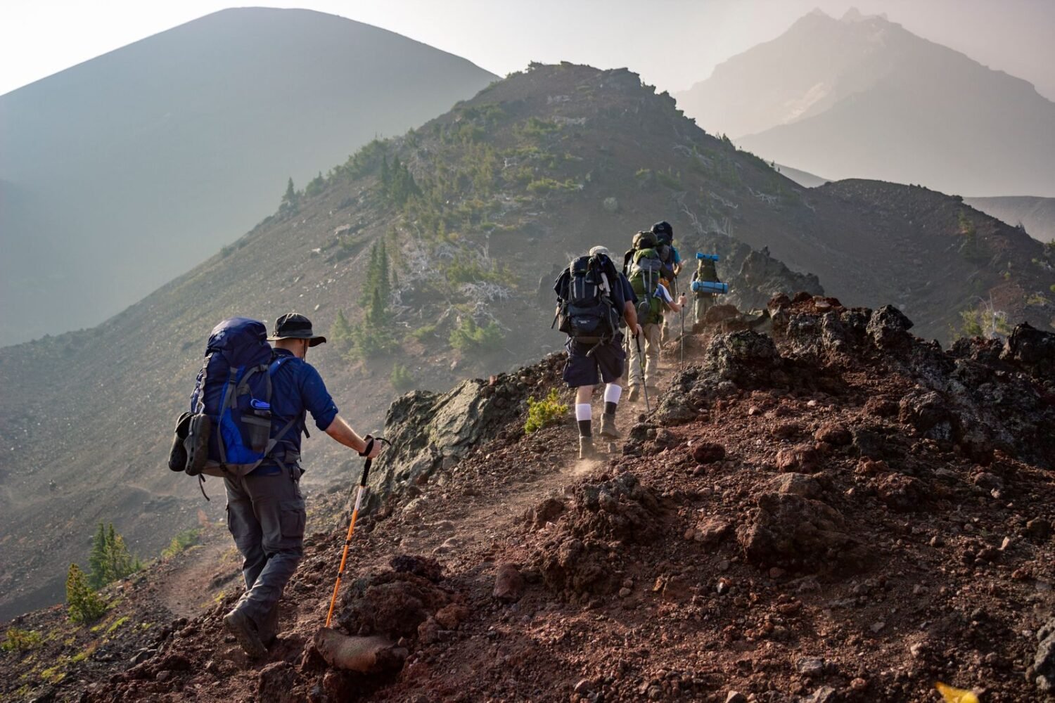 Group of hikers walking a rugged mountain trail outdoors
