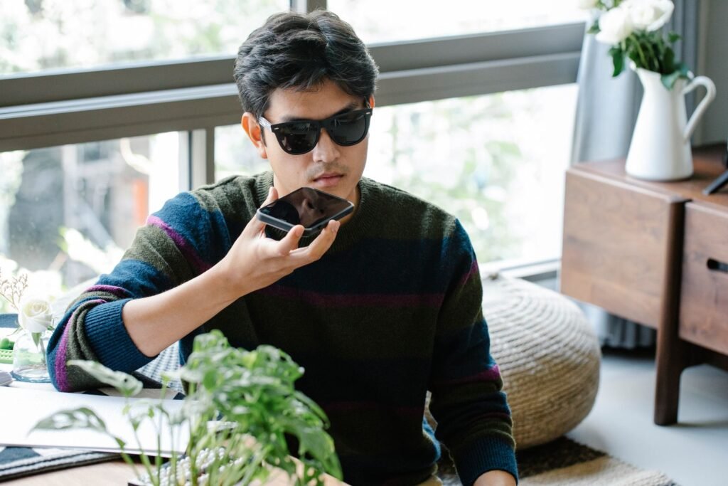 A man speaking to the voice assistant on his smartphone, illustrating the new Siri AI in iOS 27