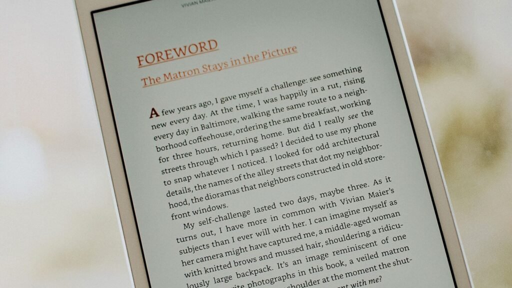 A hand holding a large touchscreen device showing a page of text, illustrating the 7.6-inch inner display of Apple's iPhone Duo foldable