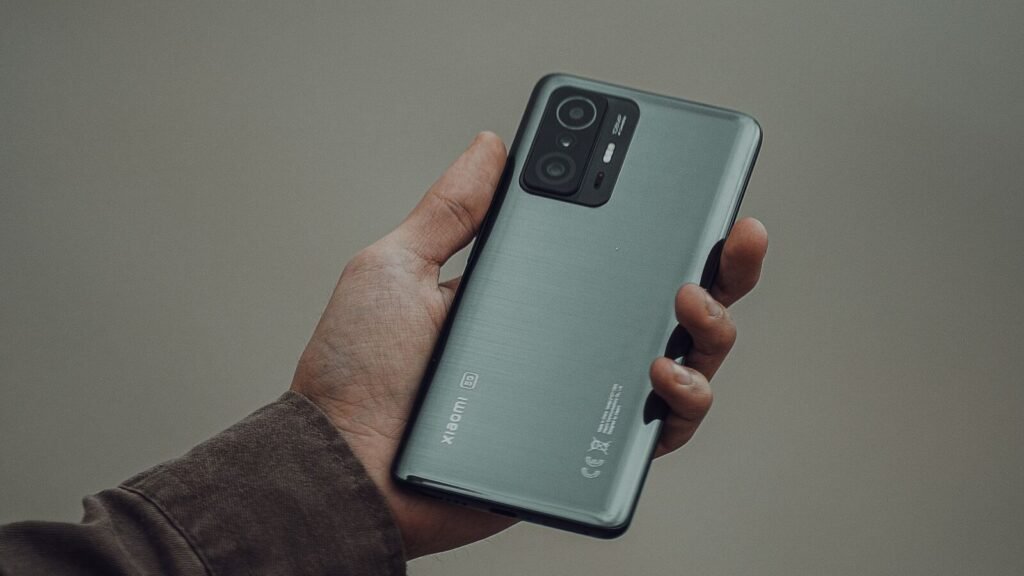 Apple’s Foldable Costs $2,000 and Drops Face ID. Four Other Things Are Missing Too. Close-up of a hand holding a modern smartphone, illustrating the rumored iPhone Ultra foldable spec sheet