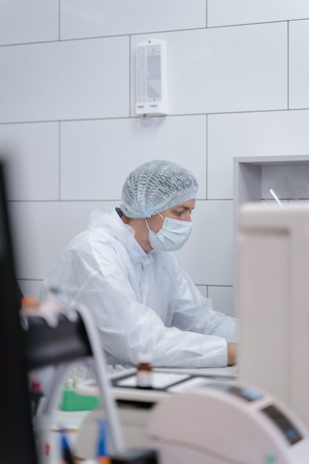 A researcher in protective gear working in a sterile laboratory environment