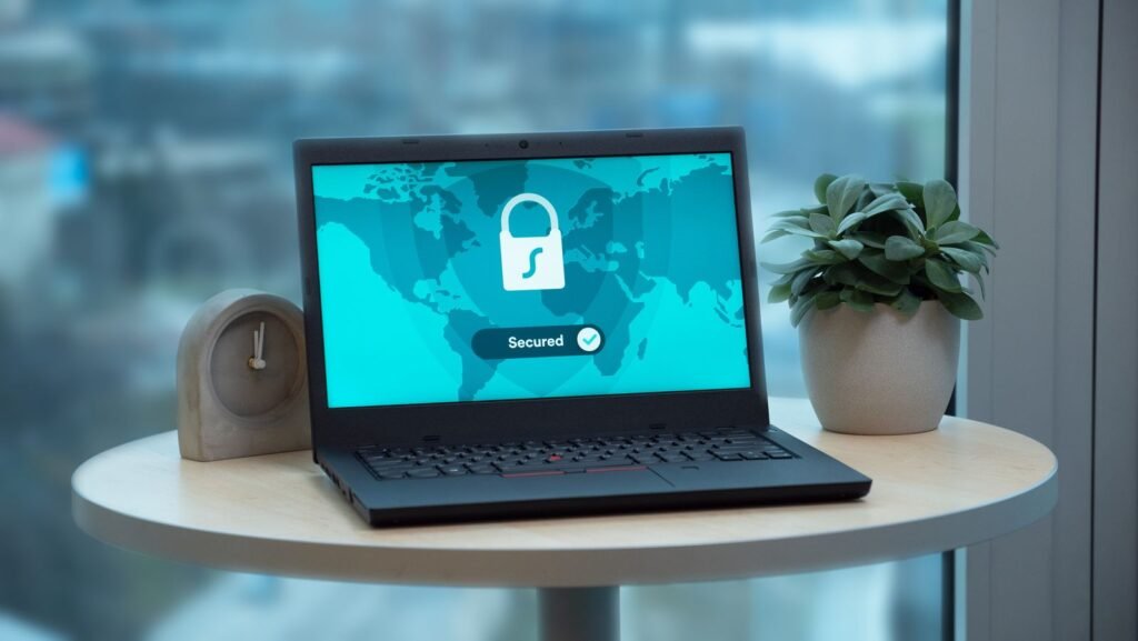 Is ChatGPT Confidential? What OpenAI Keeps and Who Can Read It Laptop on a table showing a padlock icon on screen, beside a potted plant and a clock