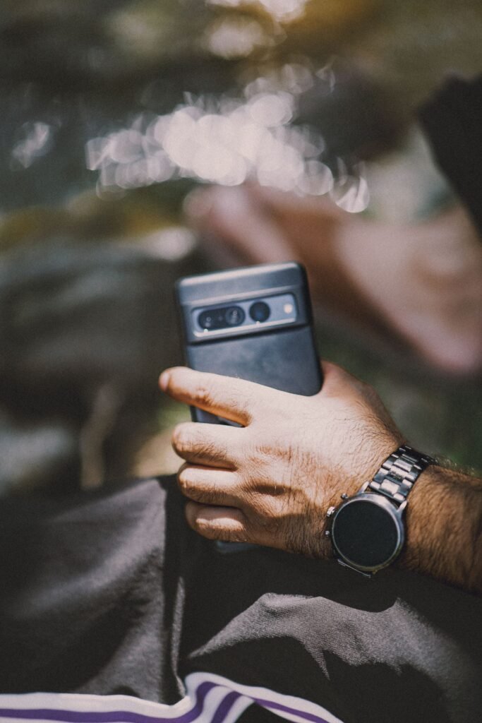 Best Smartwatches for Men in 2026: Rugged, Business, and Big-Wrist Picks Man checking a rugged smartwatch on his wrist outdoors